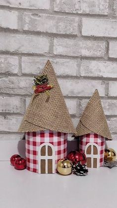 two small red and white houses with christmas decorations on the top one is made out of burlap