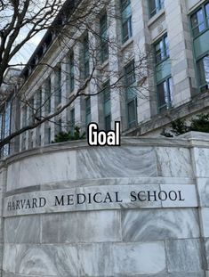 a sign that says goal in front of a building with trees and buildings behind it