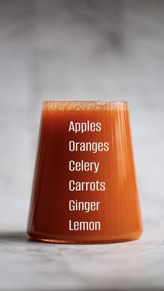 an orange juice in a glass with the words apples, oranges, celery, carrots, ginger lemon