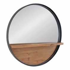 a round mirror sitting on top of a wooden shelf