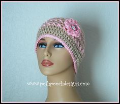 a mannequin head wearing a crocheted hat with pink flowers on it