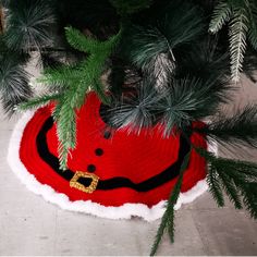 there is a santa claus hat on the floor next to some christmas tree branches and pine needles