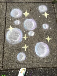 someone's feet are standing on the sidewalk with chalk drawings in front of them