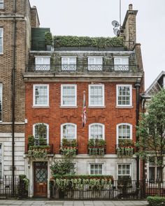 an old brick building with many windows and plants growing on it