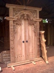 an old wooden door in the middle of a building with carvings on it's sides