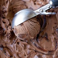 a scoop of chocolate ice cream in a bowl with a spatula on the spoon