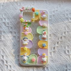 a cell phone case with some decorations on the front and back cover, sitting on a white surface