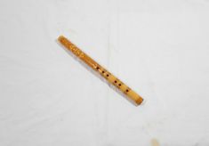 a wooden flute laying on top of a white sheet