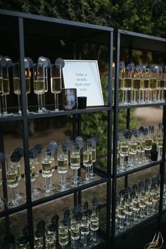 several rows of wine glasses are lined up on a shelf in front of a sign