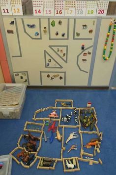 a bunch of toys are laying on the floor in front of a white board with numbers