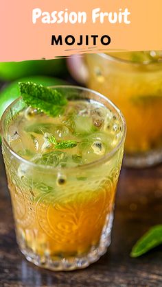 two glasses filled with mojito sitting on top of a wooden table