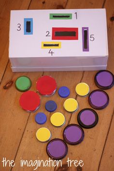 an unopened box with buttons and magnets on the floor next to it