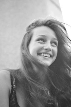 a woman with long hair smiling at the camera