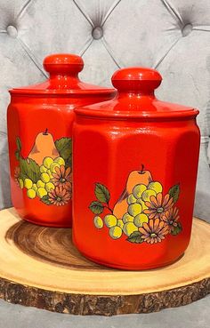 two red canisters with fruit painted on them