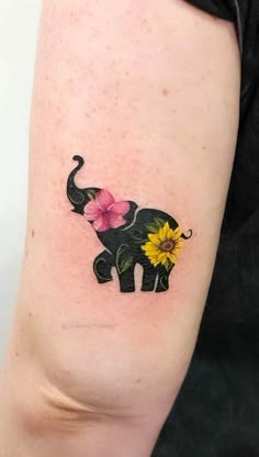 an elephant with flowers on it's arm