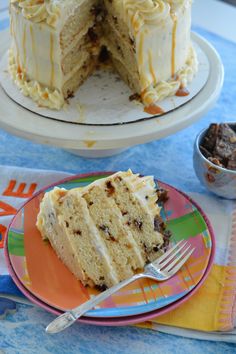 a slice of cake on a plate with the rest of the cake in the background