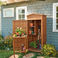 a wooden garden shed with plants and gardening tools in the door, next to it is a potted plant