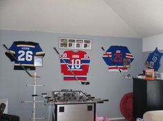 the hockey jerseys are hung on the wall above the stove in this living room area