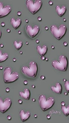 many pink hearts floating in the air with water droplets around them on a gray background