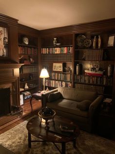 a living room filled with furniture and bookshelves next to a fire place in front of a fireplace