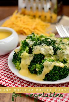 broccoli florets covered in cheese sauce on a white plate with a red and white checkered tablecloth