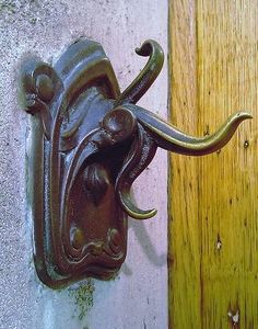 an elephant head is mounted to the side of a door handle on a wooden door