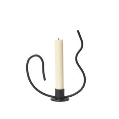 a black candle holder with a white candle on it's end and a black handle