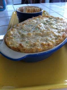 a casserole dish is shown with a fork in the foreground and a blue bowl on the right side