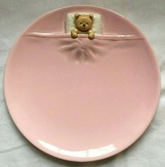 a pink plate with a teddy bear on it