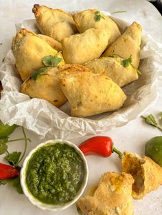 some food is on a white plate with green sauce and red peppers next to it