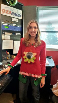 a woman standing in front of a computer desk wearing an ugly sweater and leggings