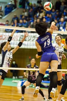 the women are playing volleyball on the court