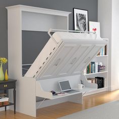 a bed with a desk underneath it and a laptop on the bottom shelf in front of it