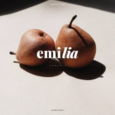 two pears sitting on top of each other with the word emelia written over them