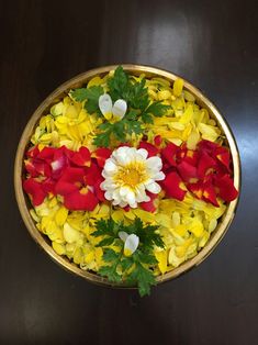 a bowl filled with flowers on top of a wooden table