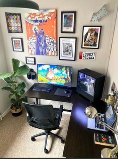 a desk with a computer and various pictures on the wall above it, along with a potted plant