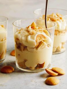 banana pudding in glass cups with spoon on table next to cookies and almonds text overlay reads our best banana pudding