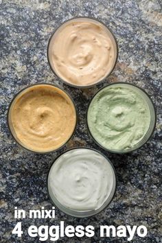 four different types of dips sitting on top of a granite counter next to each other