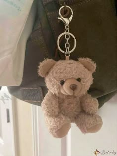 a teddy bear keychain hanging from a purse