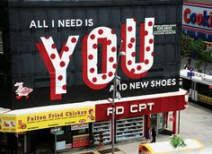 an advertisement on the side of a building that says, all i need is you and new shoes