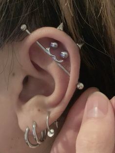 a close up of a person's ear with two piercings on top of it