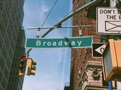 the street signs are clearly visible for everyone to see on this busy city street corner