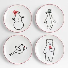 four white plates with black and red designs on them, one has a penguin, the other is a snowman