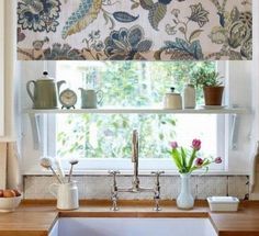 a kitchen sink sitting under a window next to a window sill with flowers on it