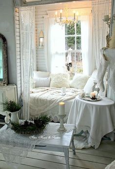 a room with white furniture and curtains on the windowsill