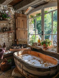 an old fashioned bathtub in the middle of a room with large windows and potted plants