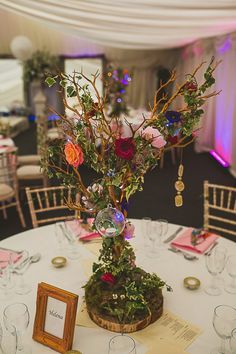 the table is set with flowers and place settings for guests to sit down at it