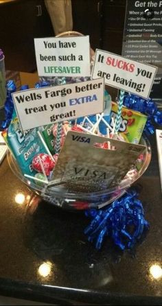 a bowl filled with lots of candy and signs on top of a counter next to a cup