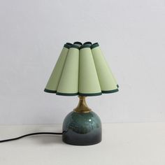 a green lamp sitting on top of a white table