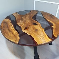 a table made out of wood and glass with black metal legs on white flooring